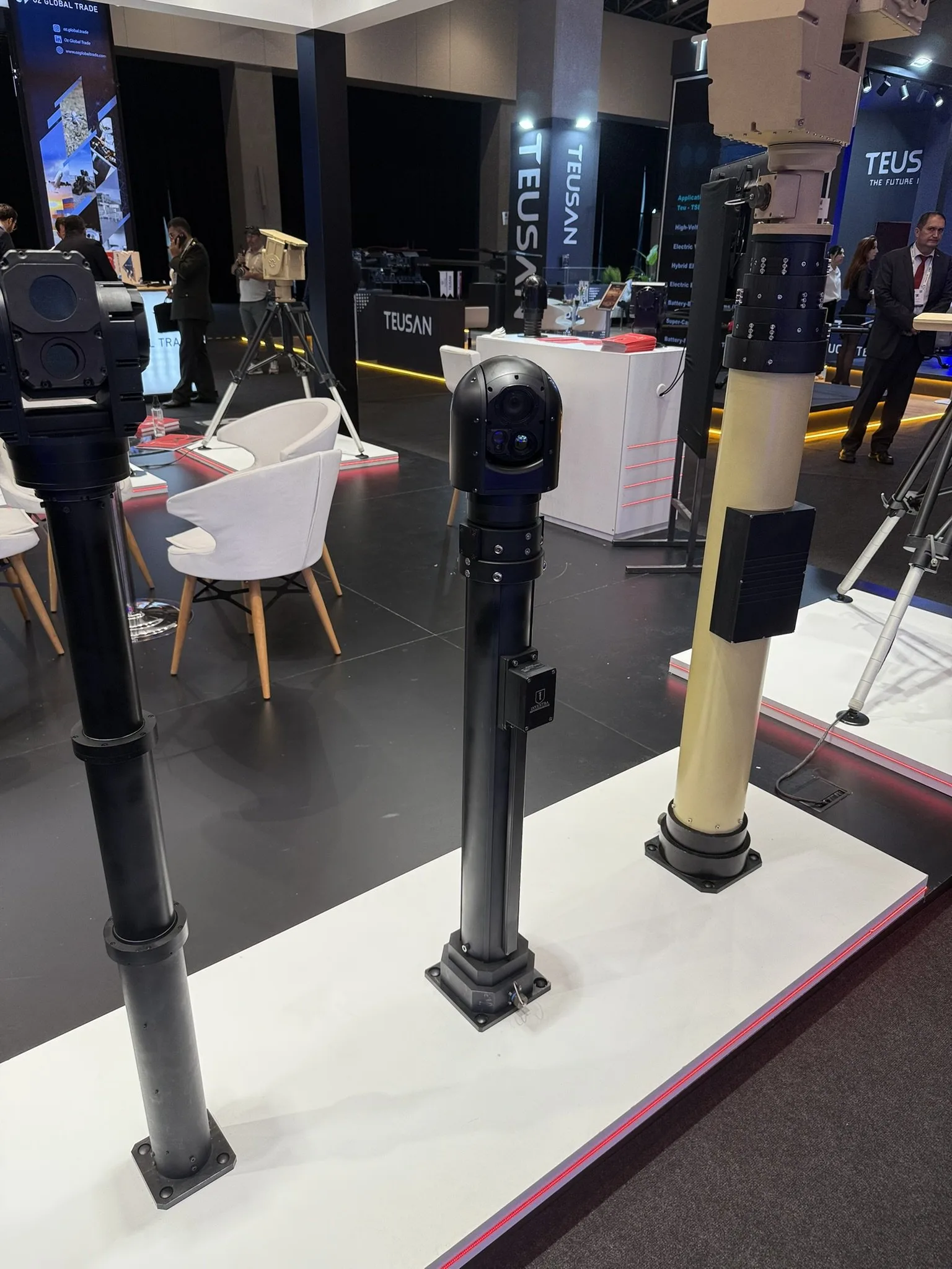 Üstlerinde kutu tipi ve kubbe tipi gimbal taşıyan siyah mastlar; sağda kum rengi mast