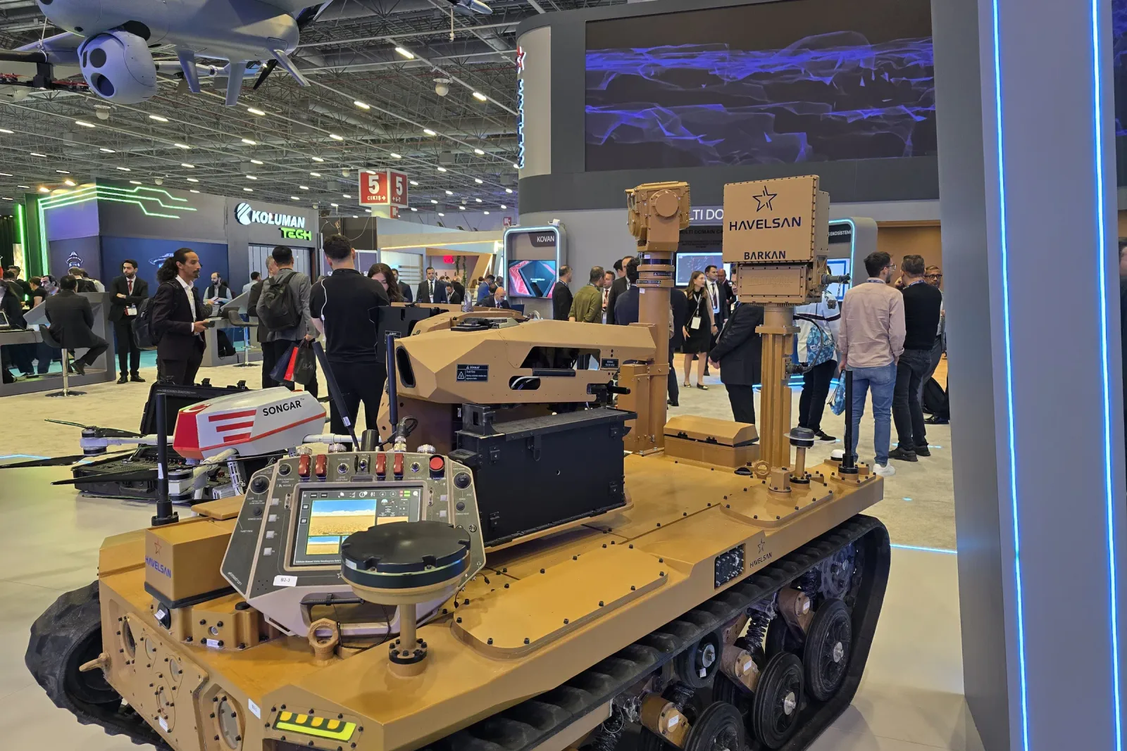 Boyunca çekilmiş paletli araç; mast ve gimbal arka güverteden yükseliyor