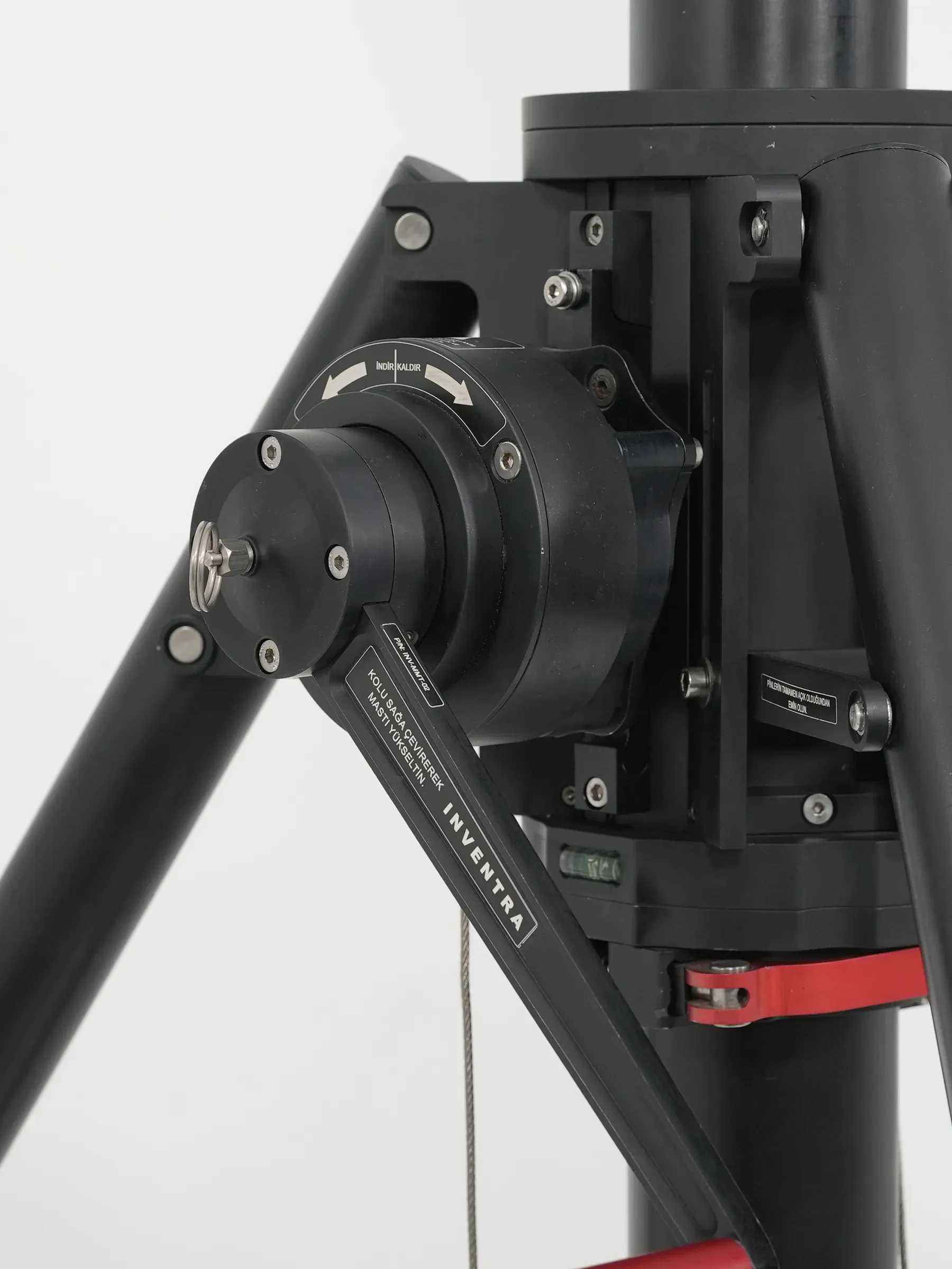 İki tripod ayağı arasında mast bileziğine monte vinç redüktörü ve kırmızı krank kolu