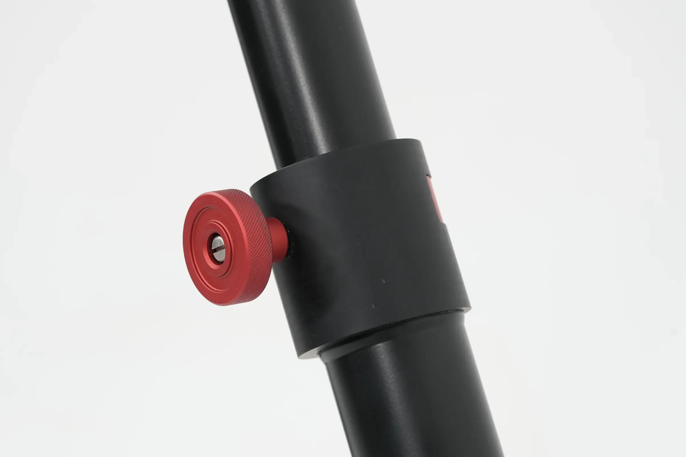 Tripod ayağının iki kademesini birleştiren siyah kelepçe bileziğindeki kırmızı kilit topuzu