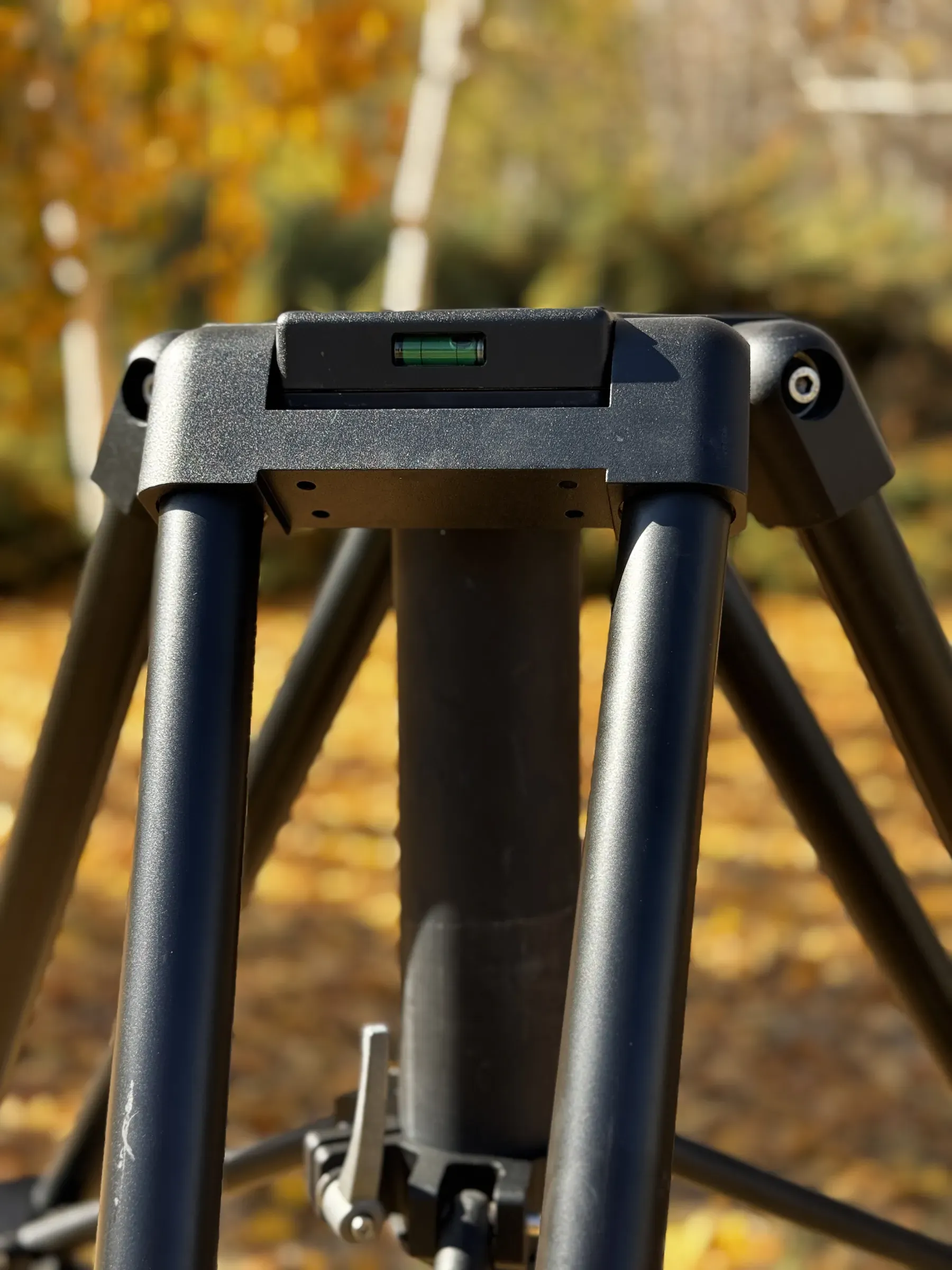 Alttan görünen TMH10 tripod başı ve merkez kolonu; su terazisi odakta