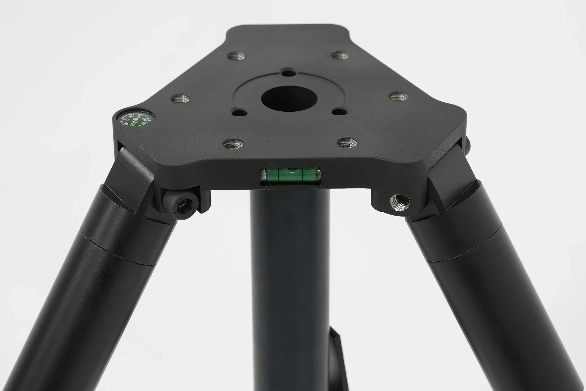 Hafif yukarıdan görünen tripod baş plakası; montaj deliği, su terazisi ve ayak kökleri